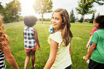 Smile, friends and portrait of girl in park for summer vacation, connection and bonding. Happiness, youth development and growth with children at outdoor playground for childhood, playful and nature