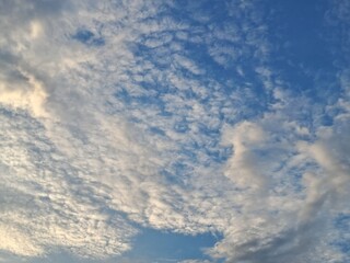 Obraz premium Beautiful altocumulus clouds on a bright blue sky background. High quality nature photography.