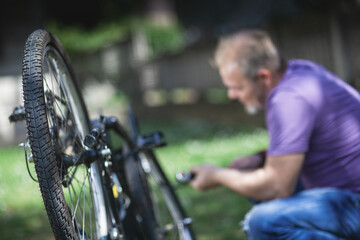 Middle Aged Man Repairing Bicycle at Home