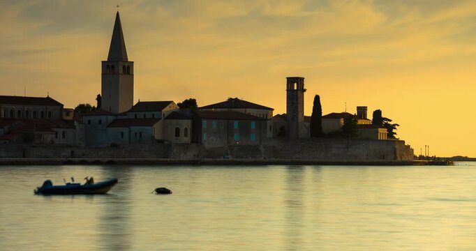 Porec, Croatia - August 13, 2025: Timelapse, slide transition. Scenic sunset view of Porec old town skyline with Euphrasian Basilica tower and blurred boat on calm Adriatic Sea in Croatia