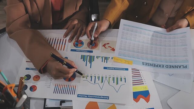 Close-up of two businessmen with pens pointing on report paper. Two Businessman discussing together in meeting room, investment projects.