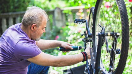 Middle Aged Man Repairing Bicycle at Home