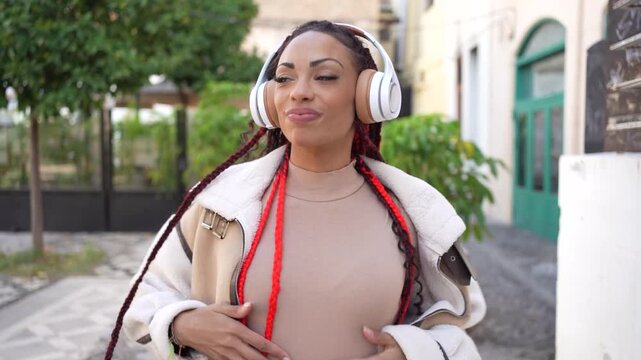 A Stylish Individual with Vibrant Braids Casually Walking in a Colorful Urban Setting