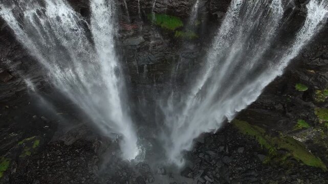 Spectacular Fossa waterfall flowing in Faroe Islands: Powerful water cascades down a dark rocky cliff on Streymoy island, a famous scandinavian landmark