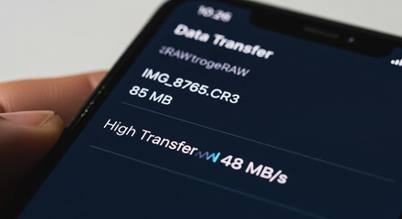Close-up view of smartphone screen displaying a high-speed data transfer process with file size, speed (48 MB/s), and dark mode interface.