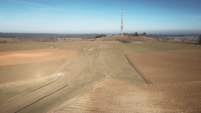Captivating drone forward flight over golden fields, hills, and TV tower under blue skies. 4K UHD 25fps smooth tracking evokes peace. Ideal for travel promos, nature docs, corporate BGs.