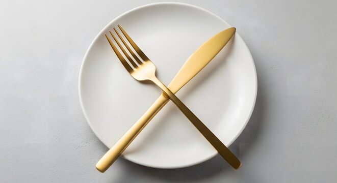 Elegant Gold Fork and Knife Crossed on White Plate for Fine Dining Concept