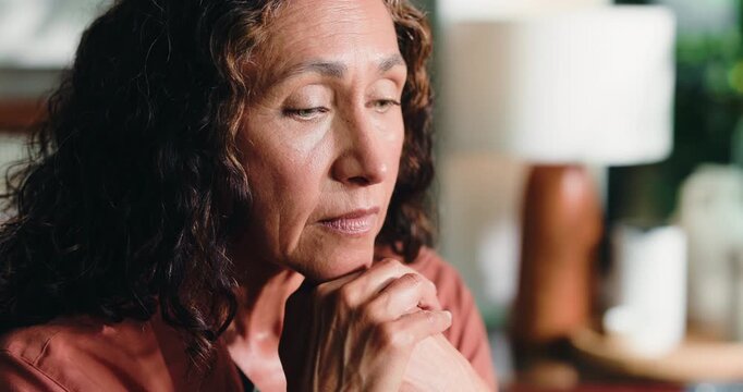 Reflection, sad and mature woman in home with loneliness, stress or remember past with regret. Thinking, depression and person in living room with anxiety for mental health, nostalgia and flashback