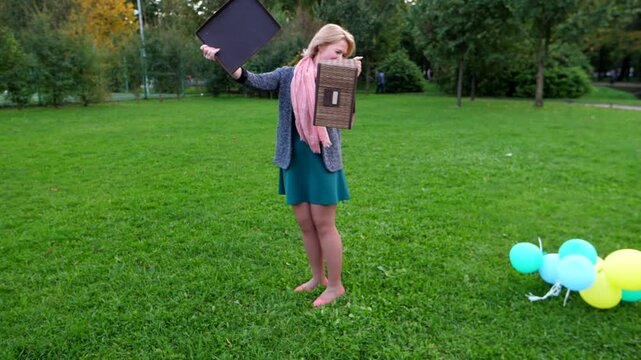 Light balloons pack move forward and fly up into box, young woman stay at park and show magic. Reverse shot of pastel coloured balls falling out to grass