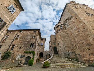 Medieval Italian street perspective showcasing the historic Anagni Cathedral apses and stone buildings under a cloudy sky in Lazio, Italy