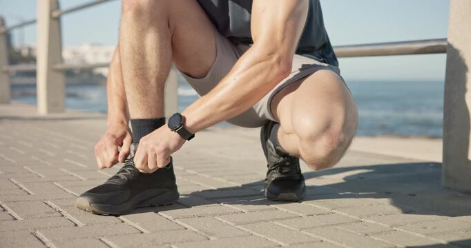 Hands, tie shoelace and man with fitness, ocean and exercise for wellness, start routine and challenge. Beach, person or sports runner with comfort, sneakers and prepare for workout and outdoor