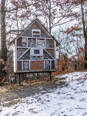 Drewniany domek dla owadów ustawiony na palach w zimowym lesie, element ochrony przyrody i bioróżnorodności. © Henryk Niestrój