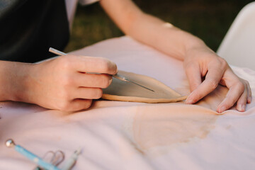 Clay Sculpting Work close-up. Clay carving shows precision and detail in ceramic crafting. Pottery artists use tools to shape and refine handmade art.