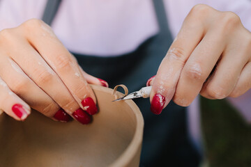 Process of sculpting clay bowls blends precision with creativity, highlighting craftsmanship and ceramic traditions. Pottery carving close-up. Artistry of carving clay pottery is shown in detail.