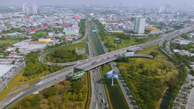 4K Aerial View Of Heavy traffic flowing through the major intersection of Vo Van Kiet Boulevard and National Route 1A in Ho Chi Minh City, Vietnam. Visible mix of cars, motorbikes, cargo trucks