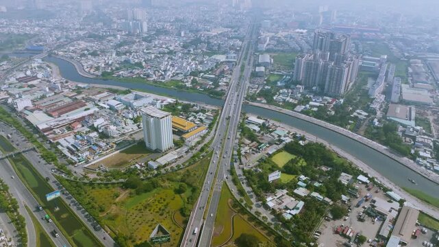 4K Aerial View Of Heavy traffic flowing through the major intersection of Vo Van Kiet Boulevard and National Route 1A in Ho Chi Minh City, Vietnam. Visible mix of cars, motorbikes, cargo trucks