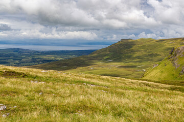 a wide panoramic view from the peak of a mountain over the Atlantic sea to the wild irish coast with a beautiful mountain range at sligo, ireland