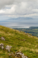 a wide panoramic view from the peak of a mountain over the Atlantic sea to the wild irish coast with a beautiful mountain range at sligo, ireland