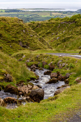 a small natural mountain river along the hiking path at the bottom of ben bulben mountain in sligo, ireland