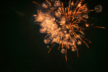 Spektakularny nocny pokaz fajerwerków na ciemnym niebie z wielobarwnymi smugami. © Pol Badger