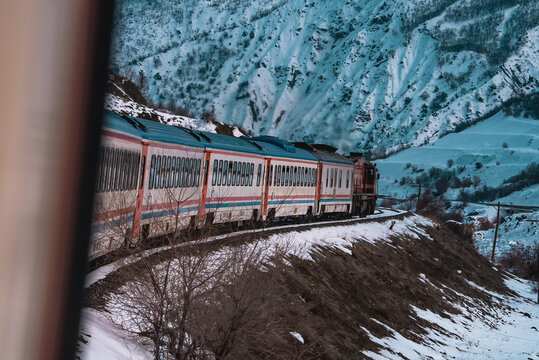 Dogu Expresi frames the moving train and snow covered roads through the window during the winter journey.