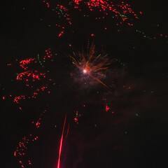 Spektakularny nocny pokaz fajerwerków na ciemnym niebie z wielobarwnymi smugami. © Pol Badger