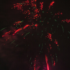 Spektakularny nocny pokaz fajerwerków na ciemnym niebie z wielobarwnymi smugami. © Pol Badger