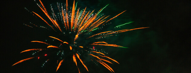 Spektakularny nocny pokaz fajerwerków na ciemnym niebie z wielobarwnymi smugami. © Pol Badger