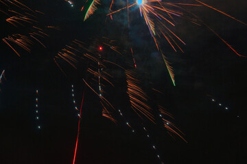 Spektakularny nocny pokaz fajerwerków na ciemnym niebie z wielobarwnymi smugami. © Pol Badger