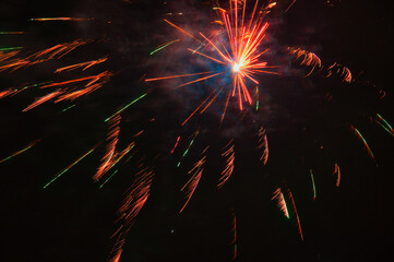 Spektakularny nocny pokaz fajerwerków na ciemnym niebie z wielobarwnymi smugami. © Pol Badger