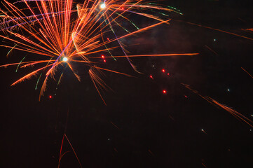 Spektakularny nocny pokaz fajerwerków na ciemnym niebie z wielobarwnymi smugami. © Pol Badger