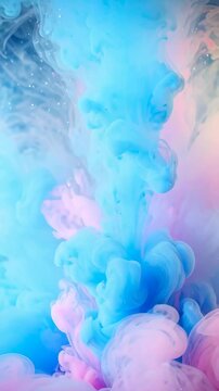 Floating puffs of blue and pink pigments mixing in water creates soft cloud-like formations and colorful gradients.