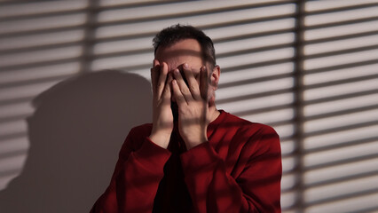 Man with headache, depression, sadness and loneliness at home