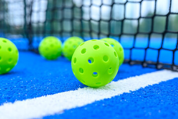 Group of Perforated Pickleball Balls Near Black Net The Concept of Sports Training