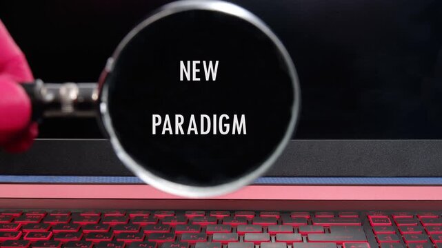 A magnifying glass is used to showcase the phrase NEW PARADIGM, gradually bringing it into sharper focus, ultimately revealing it against a background with a keyboard