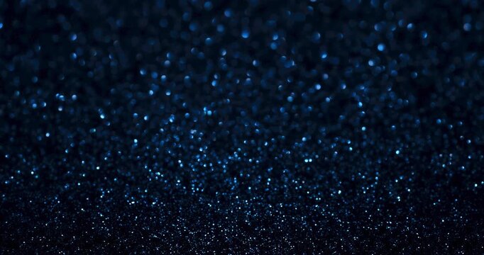 Deep blue glitter bokeh in stop-motion style with sparkling highlights and soft blur. Ideal for winter, tech, nightlife, luxury branding, and elegant abstract backdrops.