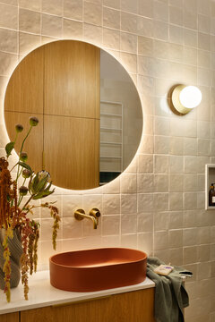 Modern Bathroom Interior with Round Mirror and Terra Cotta Sink