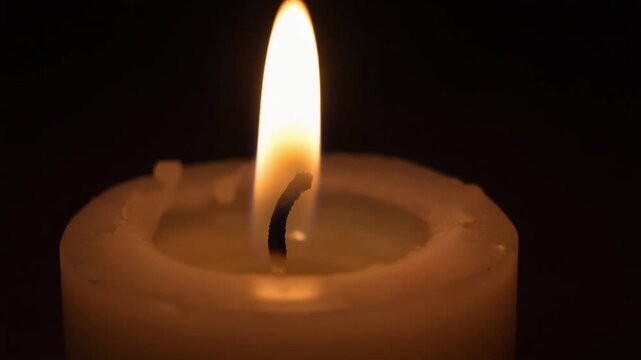 Extinguished candle in darkness symbolizing end of journey or pause