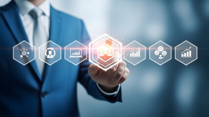 Businessman in blue suit interacting with glowing digital interface icons representing teamwork, data analysis, and network connection in modern office setting with blurred background