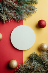 Christmas card template with fir branches and ornaments around a white circle on split background