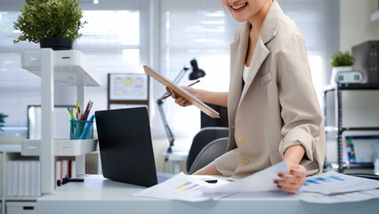 Female designer choosing color swatches in modern office for creative project with laptop in modern office