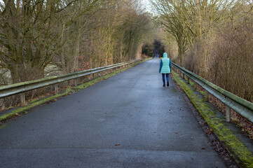 Person walking empty country road in winter