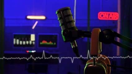 Professional microphone and headphones in a colorful radio studio interior with superimposed sound...