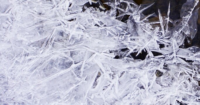 Zamarznięty l&oacute;d ukazuje swoją strukturę z bliska, z wyraźnymi kryształami i fakturą powierzchni. Naturalny, zimowy detal przyrody.