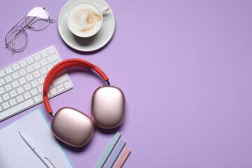 Obraz premium Headphones, smartphone, computer keyboard, coffee and stationery on violet background, flat lay. Space for text