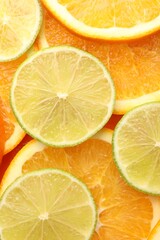 Fototapeta premium Fresh orange and lime slices as background, top view