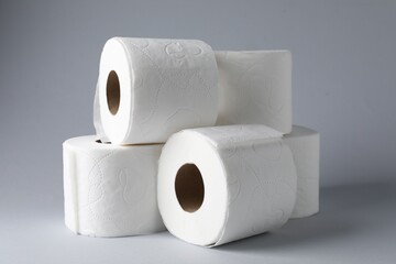 Fototapeta premium Toilet paper rolls on light grey background, closeup