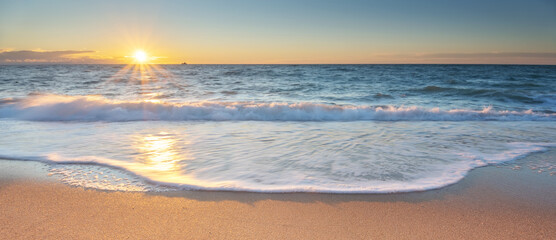 Summer on the beach. Sandy seashore during sunset.