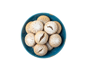 Arabic maamoul cookies filled with dates and dusted with powdered sugar, presented in a blue dish from a top view, set against a white background.