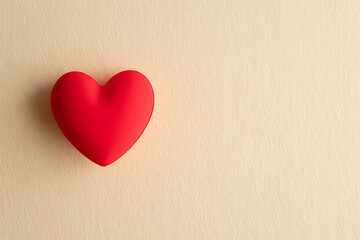 Obraz premium Vibrant red heart on soft beige background for Valentine's Day
